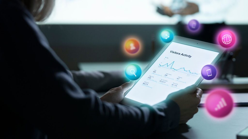 Ícones de redes sociais e aplicativos flutuando sobre uma mesa de trabalho, representando o marketing digital como parte do mix de marketing.